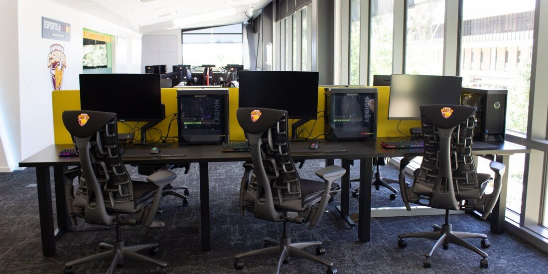 A section of the Esports Academy showing 3 Desktop Computers. The computers have clear Legion hardware casings so you can see the inside of the computer motherboard and hardware.